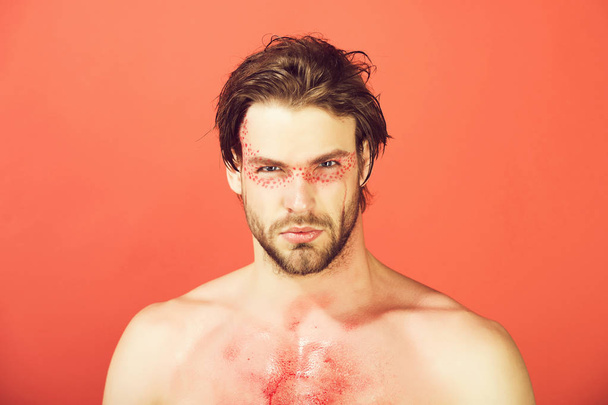 handsome man with creative fashionable makeup on red background - Foto, imagen
