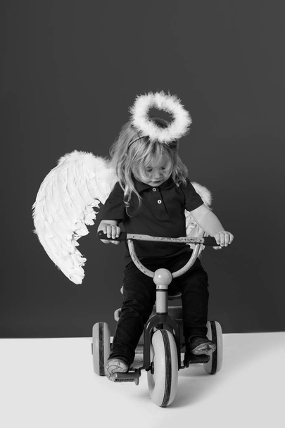 angel boy for valentine greeting, beautiful cupid on bike - Foto, Imagem