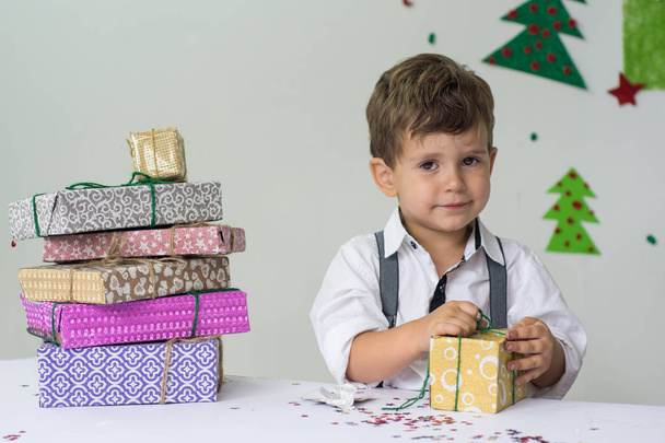 Маленький мальчик улыбается с подарком. Праздники, подарки, фестивали, концепция x-mas
 - Фото, изображение