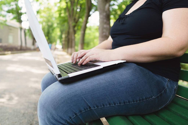 obese female worker with laptop working outdoors - Zdjęcie, obraz