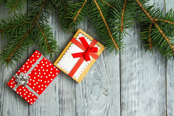 dva vánoční dárky v slavnostní pole na šedé vintage dřevěné pozadí s zelenou větví - Fotografie, Obrázek