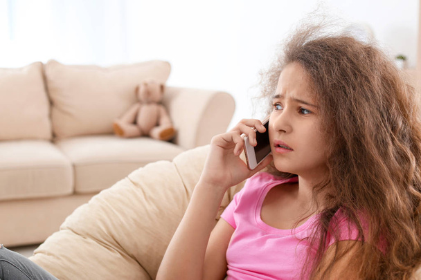 Depresivní teenager mluví na mobilním telefonu v křesle - Fotografie, Obrázek