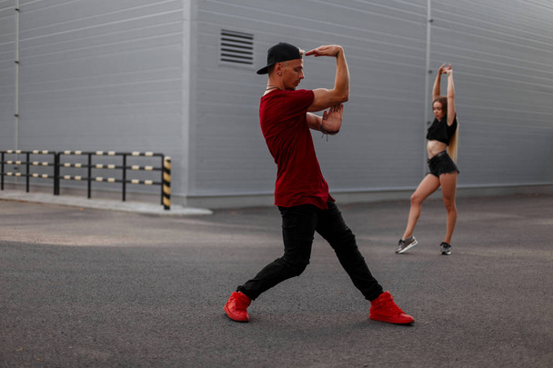 Stylový hezký hip-hopová tanečnice v módní oblečení s víčkem tančí na ulici. Sexy dívka tanečnice na pozadí - Fotografie, Obrázek
