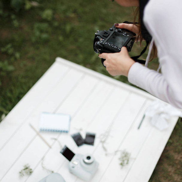 Girl photographer takes pictures of objects. Female hands hold the camera. Woman working with stock photography - Zdjęcie, obraz