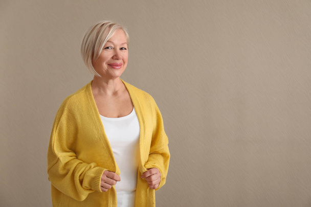 Portrait of beautiful mature woman on color background - Foto, afbeelding