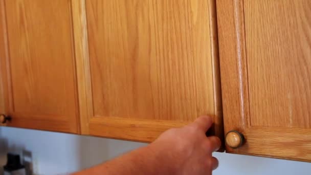 Uma mão abre o armário da cozinha, remove um prato de jantar e fecha a porta
 - Filmagem, Vídeo