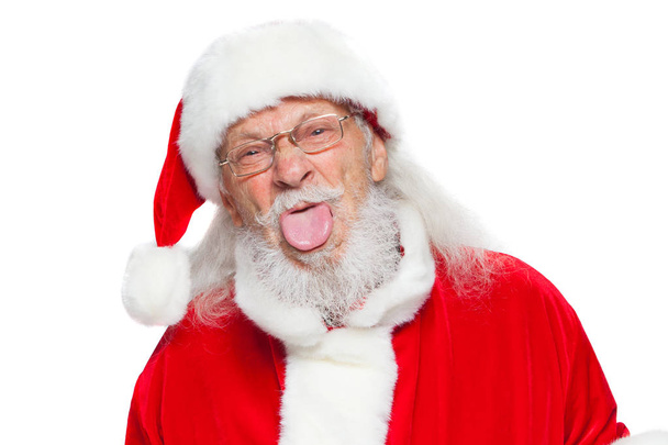 Christmas. Good Santa Claus in white gloves shows faces, grimaces, shows his tongue. Not standard behavior. Isolated on white background. - Фото, зображення