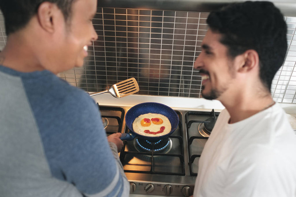 gay los hombres comer desayuno cocina huevos en casa cocina
 - Foto, Imagen
