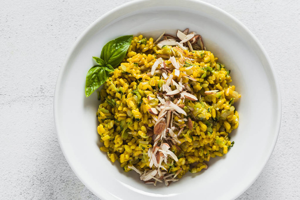 risotto with zucchini and turmeric or saffron in a plate on the table. healthy italian food - Photo, image