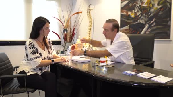 Doctor explicando a la mujer dolores de espalda y columna vertebral al hernia de disco. - Imágenes, Vídeo