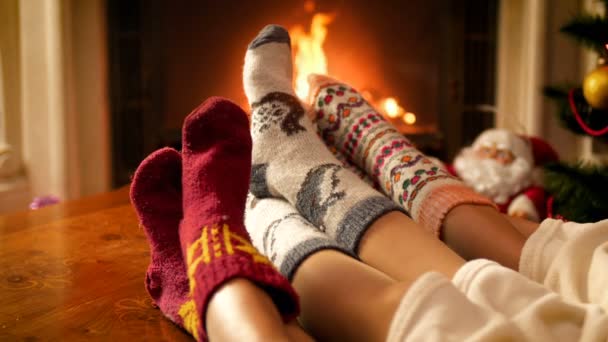 4k video di famiglia in calzini di lana caldi seduti vicino al camino la vigilia di Natale
 - Filmati, video