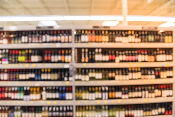 Imagen borrosa de los estantes de vino con etiquetas de precios en exhibición en la tienda en Houston, Texas, EE.UU. Filas desenfocadas de botellas de licor de vino en el estante del supermercado. Bebidas alcohólicas antecedentes abstractos
. - Foto, imagen