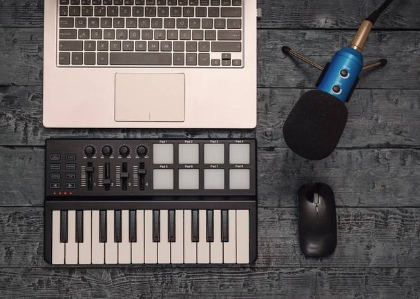 Elektronische muziek mixer en draad microfoon op een zwarte houten tafel. Apparatuur voor de muziek Studio. Het uitzicht vanaf de top. Plat leggen. - Foto, afbeelding