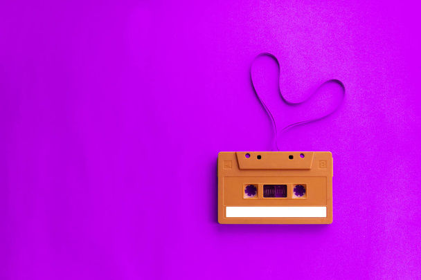 Stary audio kaseta magnetofonowa z filmu kształt serca na różowym tle. - Zdjęcie, obraz