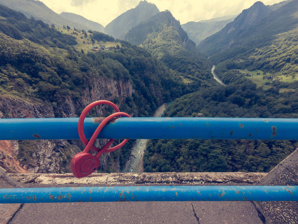 Lovelock rouge enchaîné à une clôture métallique sur un pont
. - Photo, image