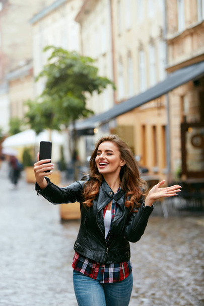 Nainen videopuhelu puhelimessa kadulla, valokuvien ottaminen
  - Valokuva, kuva