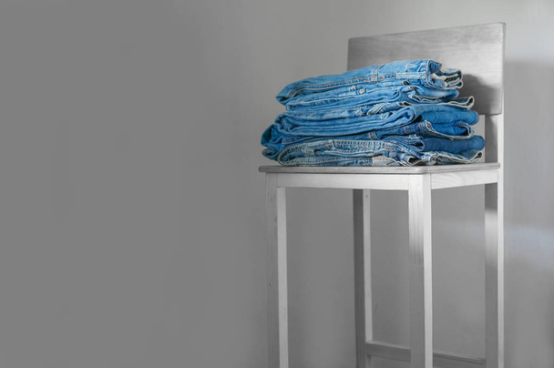 Jeans. Stylish clothes stacked over grey background, minimal  - Photo, Image
