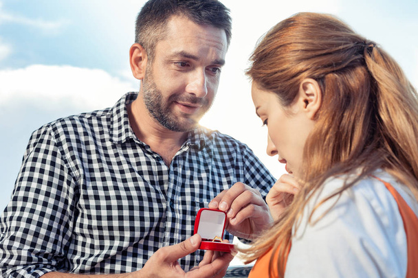 Positive excited woman looking at the engagement ring - 写真・画像