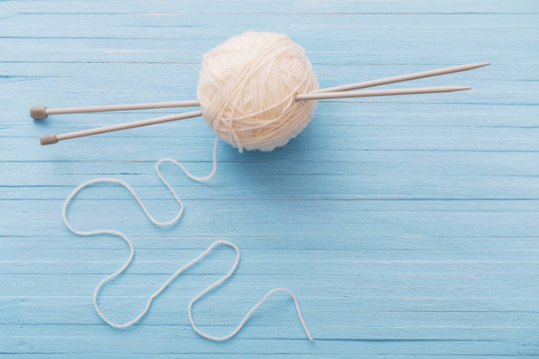 Knitting and knitting needles on a wooden surface - Valokuva, kuva
