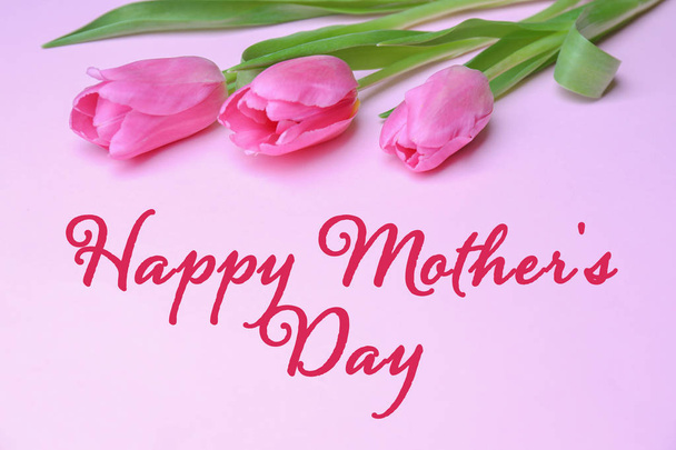 Beautiful tulips and greeting Happy Mother's Day on color background - Фото, изображение