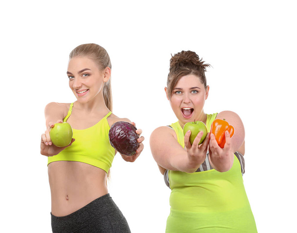 Mujeres jóvenes con verduras frescas y frutas sobre fondo blanco. Concepto de alimentación dietética
 - Foto, Imagen