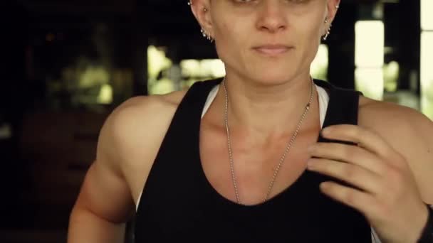 Attractive girl running on the treadmill in the gym . Full face portrait - Felvétel, videó