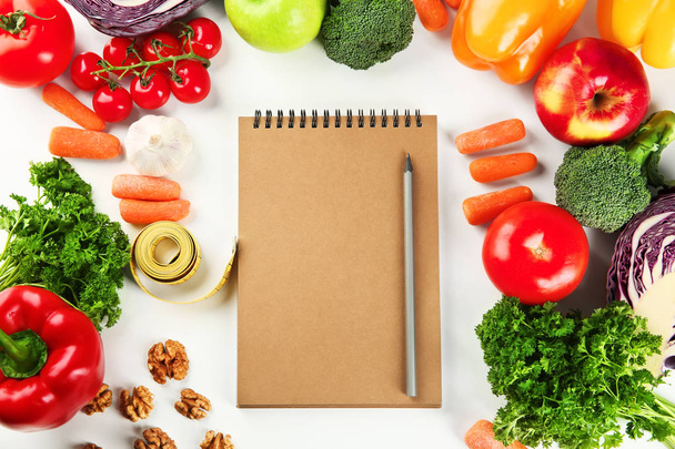 Plochou položit složení s dietní jídlo, měřicí pásky a notebook na bílém pozadí - Fotografie, Obrázek