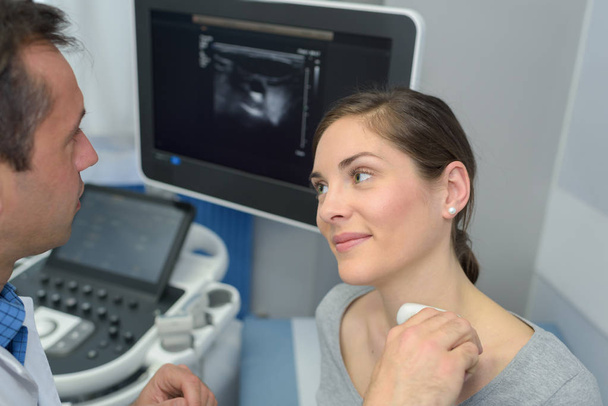 woman getting an ultrasound scan on neck by doctor - Fotoğraf, Görsel