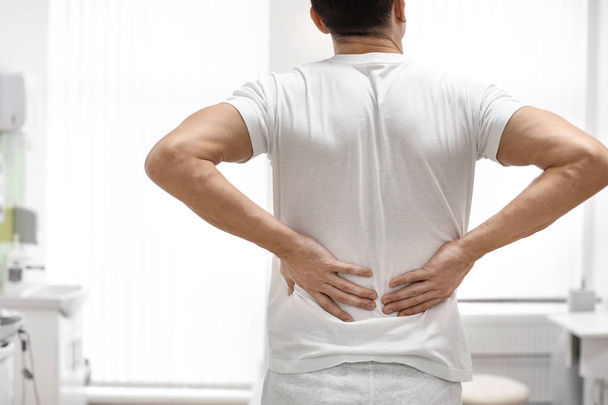 Человек, страдающий от болей в спине в кабинете ортопеда
 - Фото, изображение