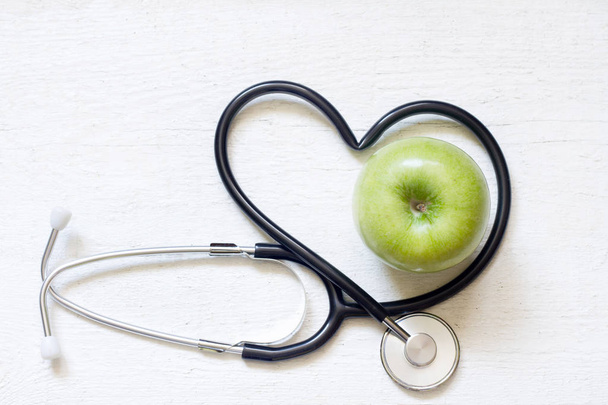 Alternative medicine healthy  sign concept with stethoscope heart and green apple on white background - Fotoğraf, Görsel