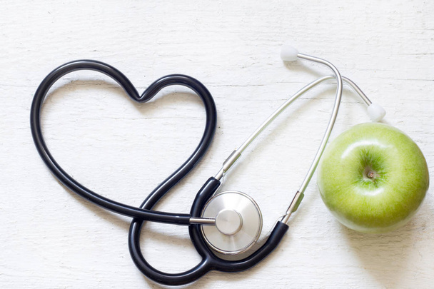 Medicina alternativa concepto de signo saludable con estetoscopio corazón y manzana verde sobre fondo blanco
 - Foto, Imagen