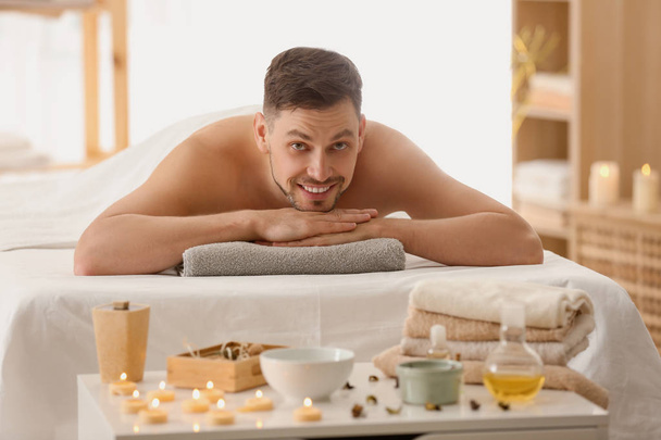 Człowiek leżący na stole do masażu w spa salon - Zdjęcie, obraz