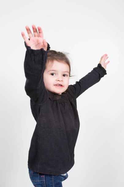 kaunis tyttö lapsi kädet ilmassa valkoisella taustalla
 - Valokuva, kuva