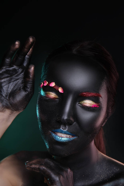 Retrato de una hermosa joven con maquillaje surrealista sobre fondo oscuro
 - Foto, imagen