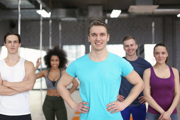 Sporty man with group of athletes in gym - Foto, Imagem