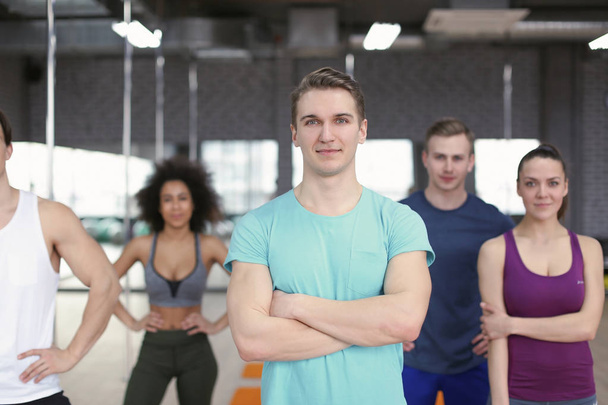 Sporty man with group of athletes in gym - Photo, Image
