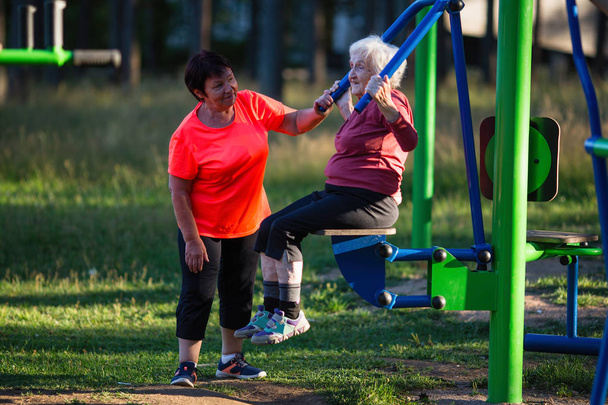 Mulheres idosas estão fazendo exercícios no playground esportivo do Parque
. - Foto, Imagem