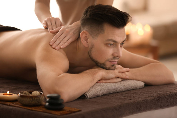 Hombre joven recibiendo masaje en el salón de spa
 - Foto, Imagen