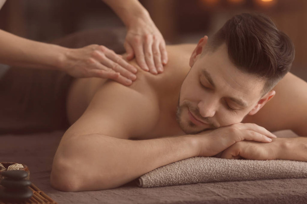 Giovane uomo che riceve un massaggio al salone spa
 - Foto, immagini