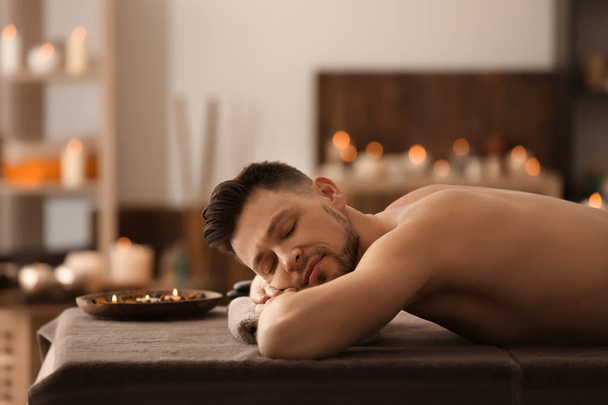 Jovem relaxante na mesa de massagem no salão de spa
 - Foto, Imagem