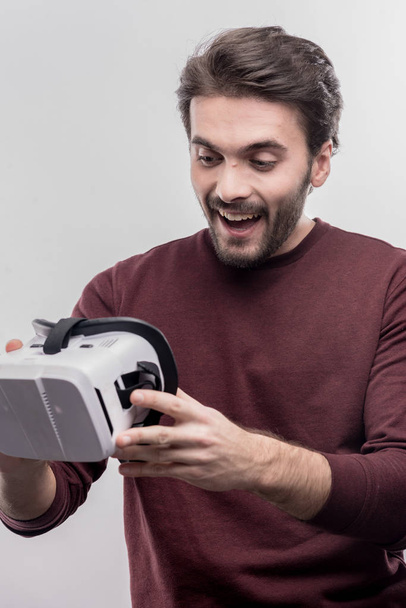 Great fan of video games holding virtual reality glasses in hands - Фото, изображение