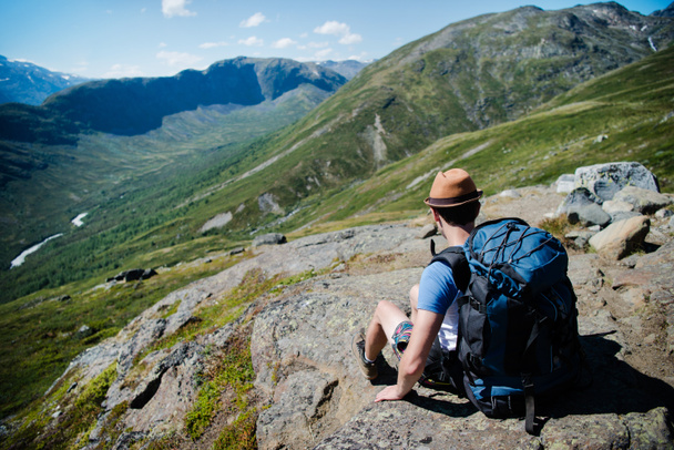 traveler with backpack resting on Besseggen ridge in Jotunheimen National Park, Norway - Photo, Image