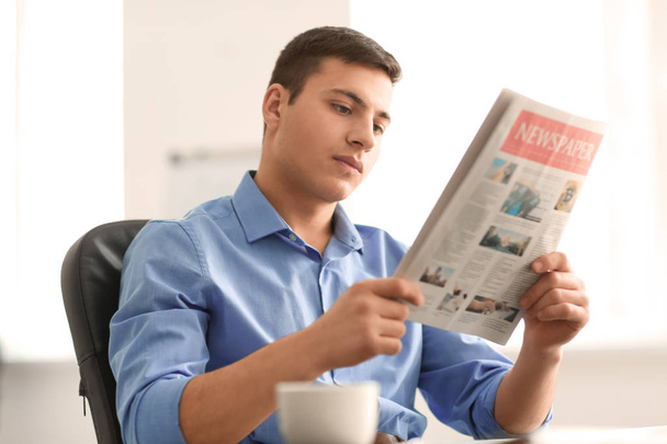 Handsome businessman reading newspaper in office - Photo, Image