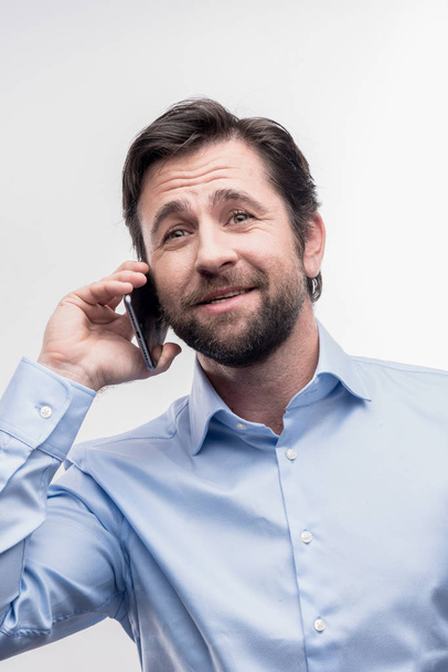 Caring dark-haired husband calling his lovely wife during break at work - Фото, изображение