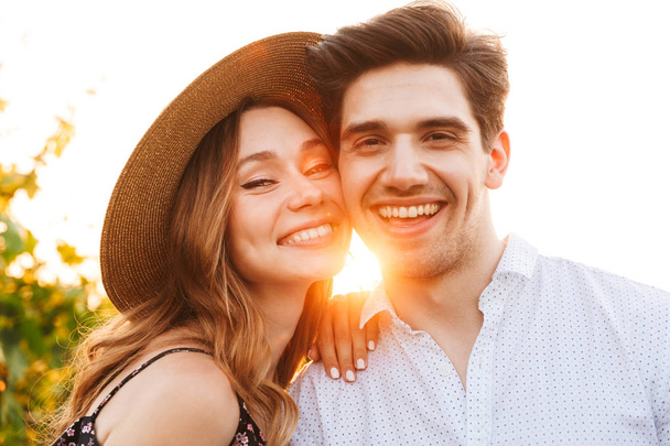 Photo of young cute happy loving couple outdoors looking camera. - Фото, изображение