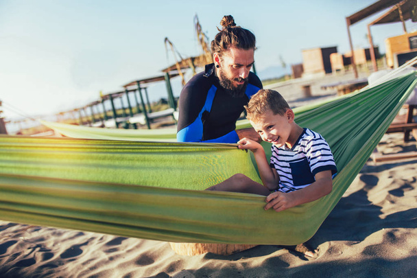 Ojciec i syn bawią się na plaży razem portret zabawy szczęśliwy styl życia - Zdjęcie, obraz