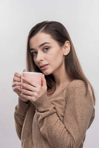 Dark-haired appealing woman drinking hot cocoa on cold evening - Фото, изображение