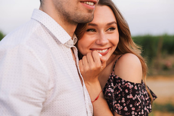 Picture of young happy cute loving couple outdoors hugging with each other. - Photo, Image
