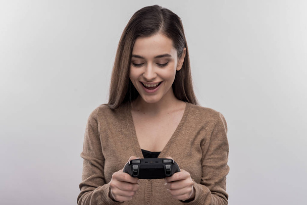 Funny cute woman holing joystick playing new video game - Фото, изображение