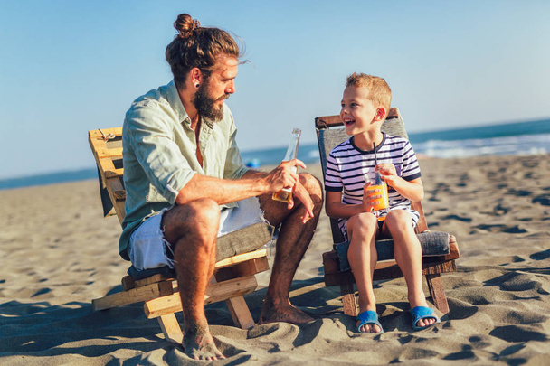 Vater und Sohn amüsieren sich gemeinsam am Strand - Foto, Bild
